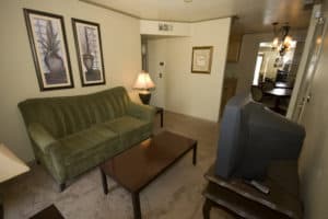 Cameron room with TV, futon, and an open floor plan - Emerald Suites