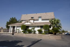 Exterior of Cameron location, stucco roof and white walls - Emerald Suites